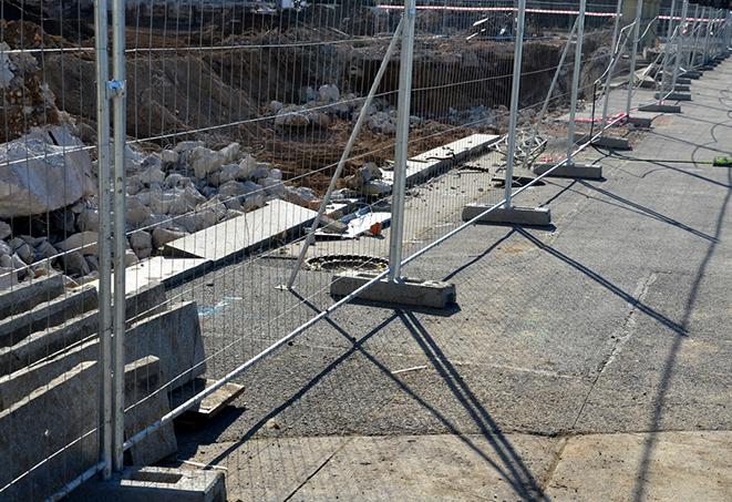 construction workers unloading temporary fence panels for their construction site